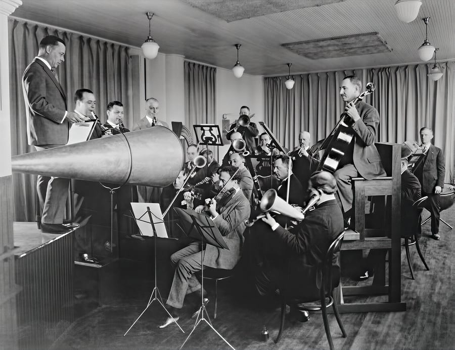 An early acoustic recording session, performers playing into a horn cut directly to an Edison cylinder